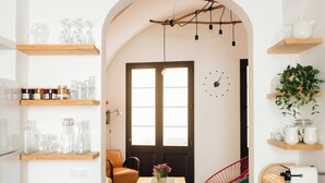Une cuisine moderne avec des étagères en bois, une table à manger et un luminaire suspendu.