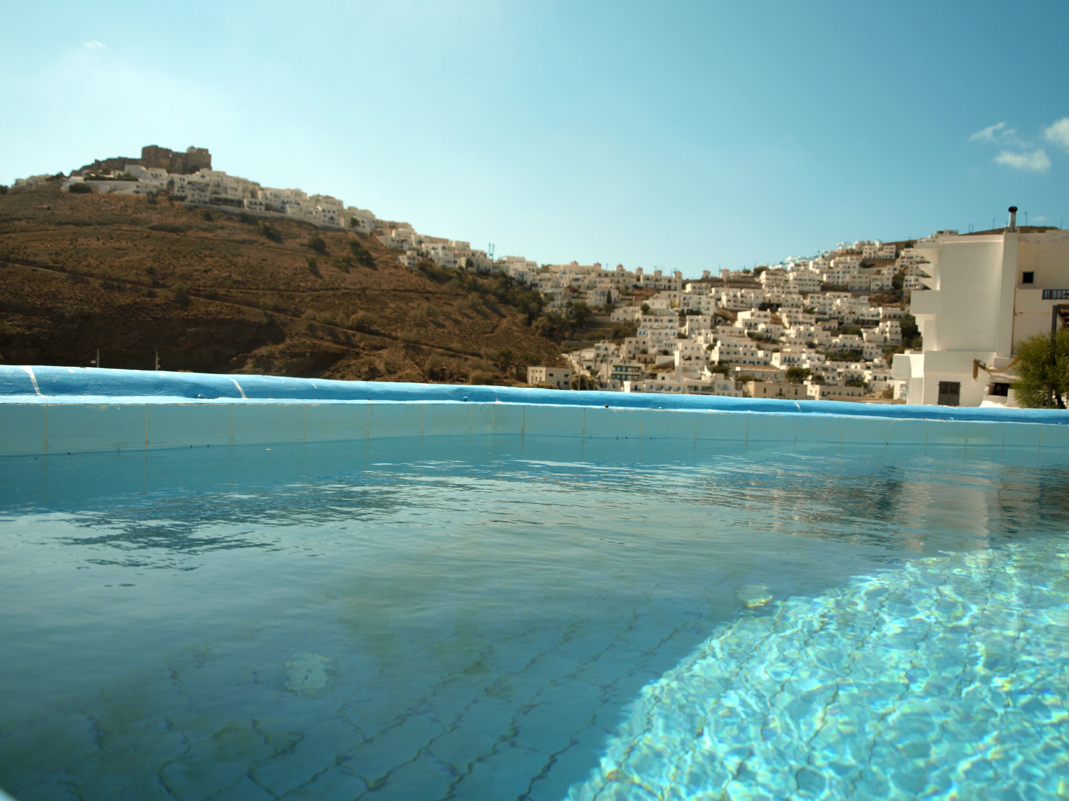 Una piscina al aire libre, sombrillas, tumbonas