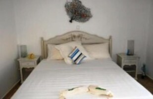 Un dormitorio con una cama grande, dos mesitas de noche y un adorno en la pared.