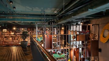 A spacious interior with high ceilings, exposed ductwork, and a variety of shelves displaying collectibles and memorabilia.