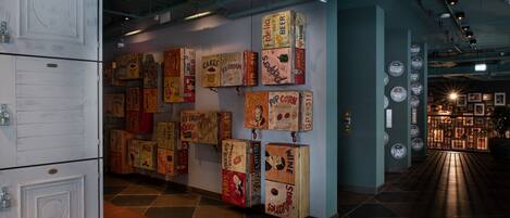 Un pasillo con cajas de estilo vintage en la pared, una zona de estar y una entrada bien iluminada.