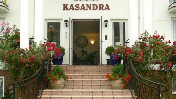 L’entrée de La Residence Kasandra se distingue par un escalier en pierre et une rampe en fer forgé.