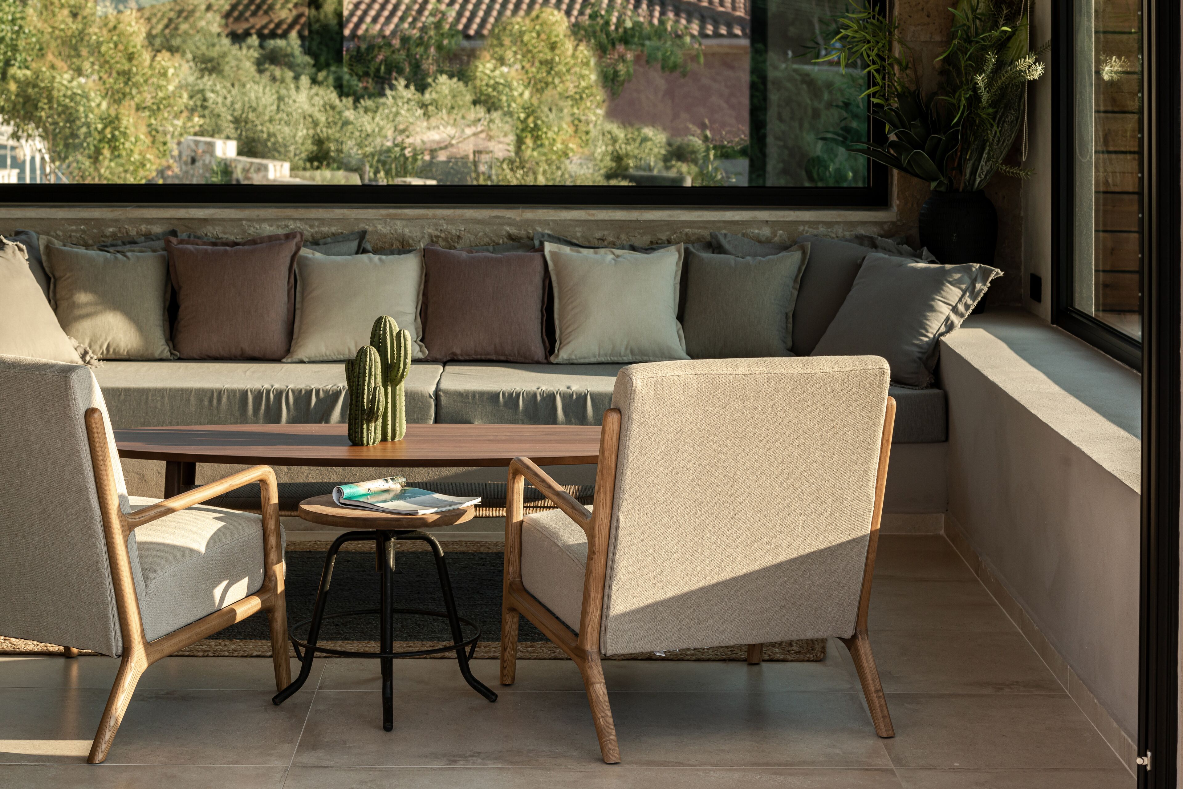 A cozy seating area with a sofa and two chairs, a small table, and a cactus plant.