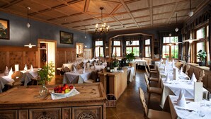A restaurant with wooden interiors, multiple dining tables, and a central bar area. - Ostaria Posta (San Martino in Badia)