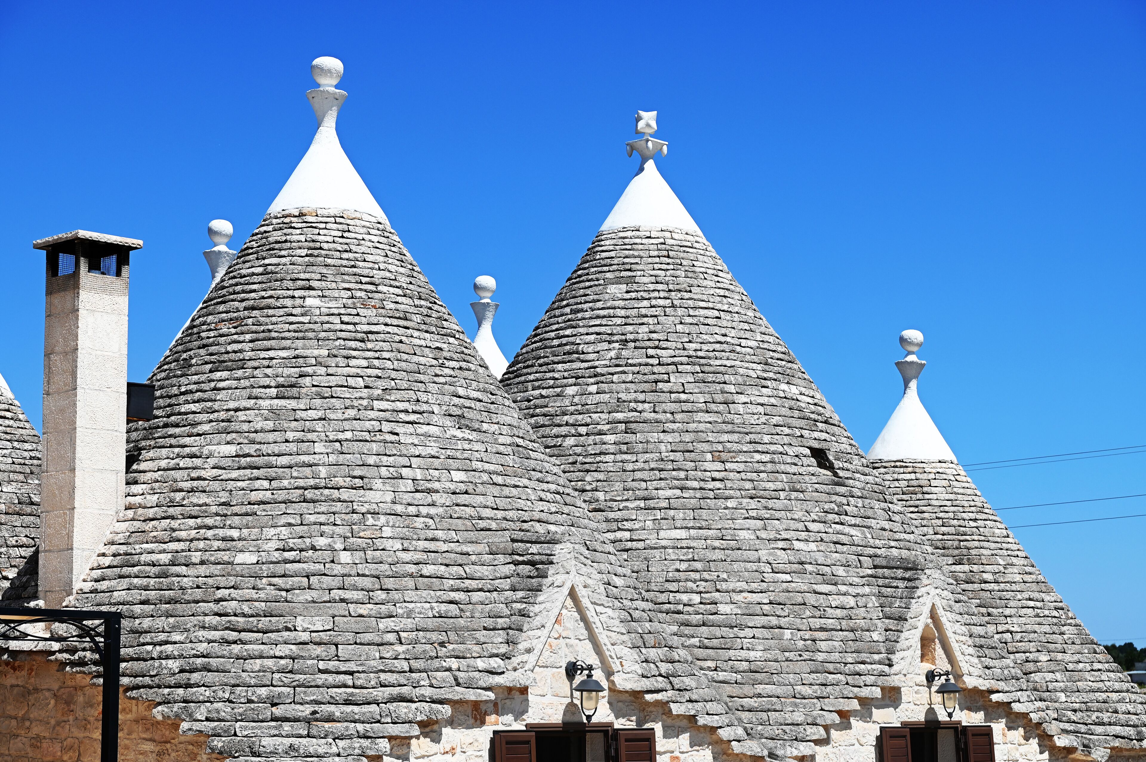 Una hilera de edificios tradicionales con techos de piedra y forma cónica, y una torre central.
