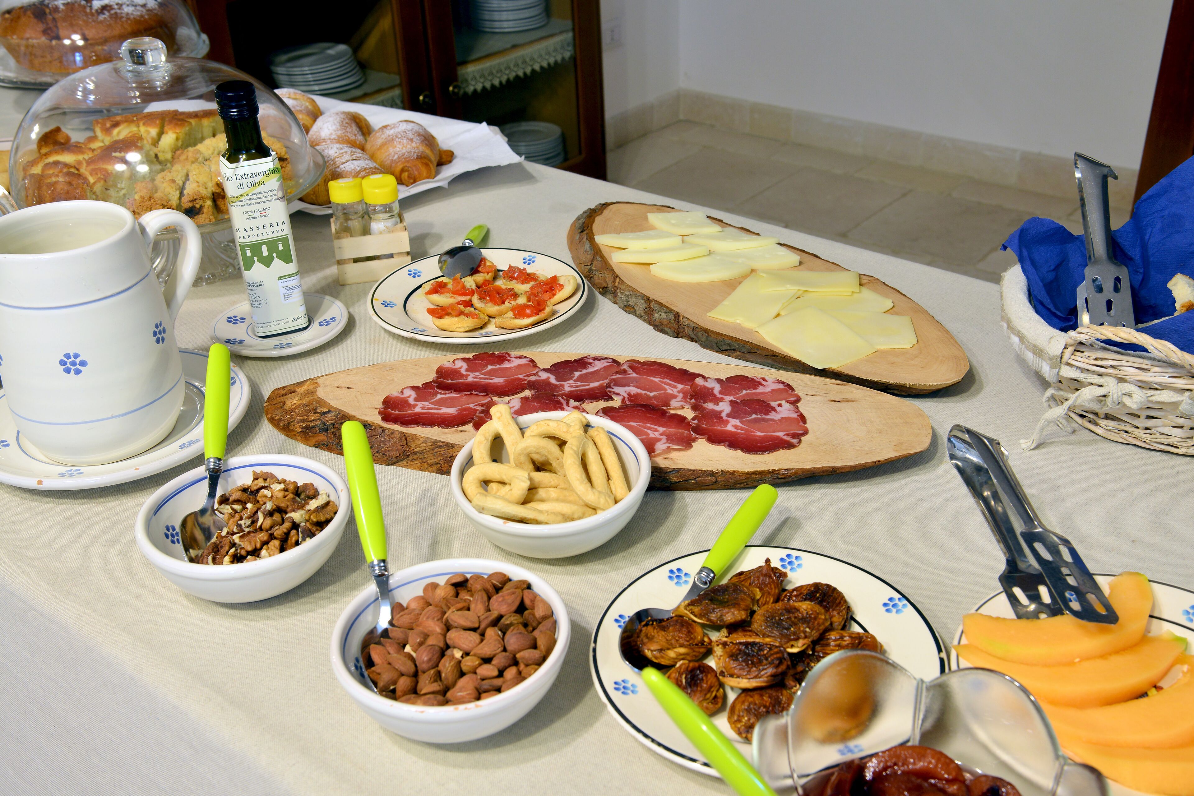 Een tafel met verschillende soorten eten, waaronder kaas, vlees en fruit.