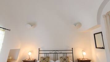 A neatly arranged bedroom with a bed, bedside tables, and a wooden table.