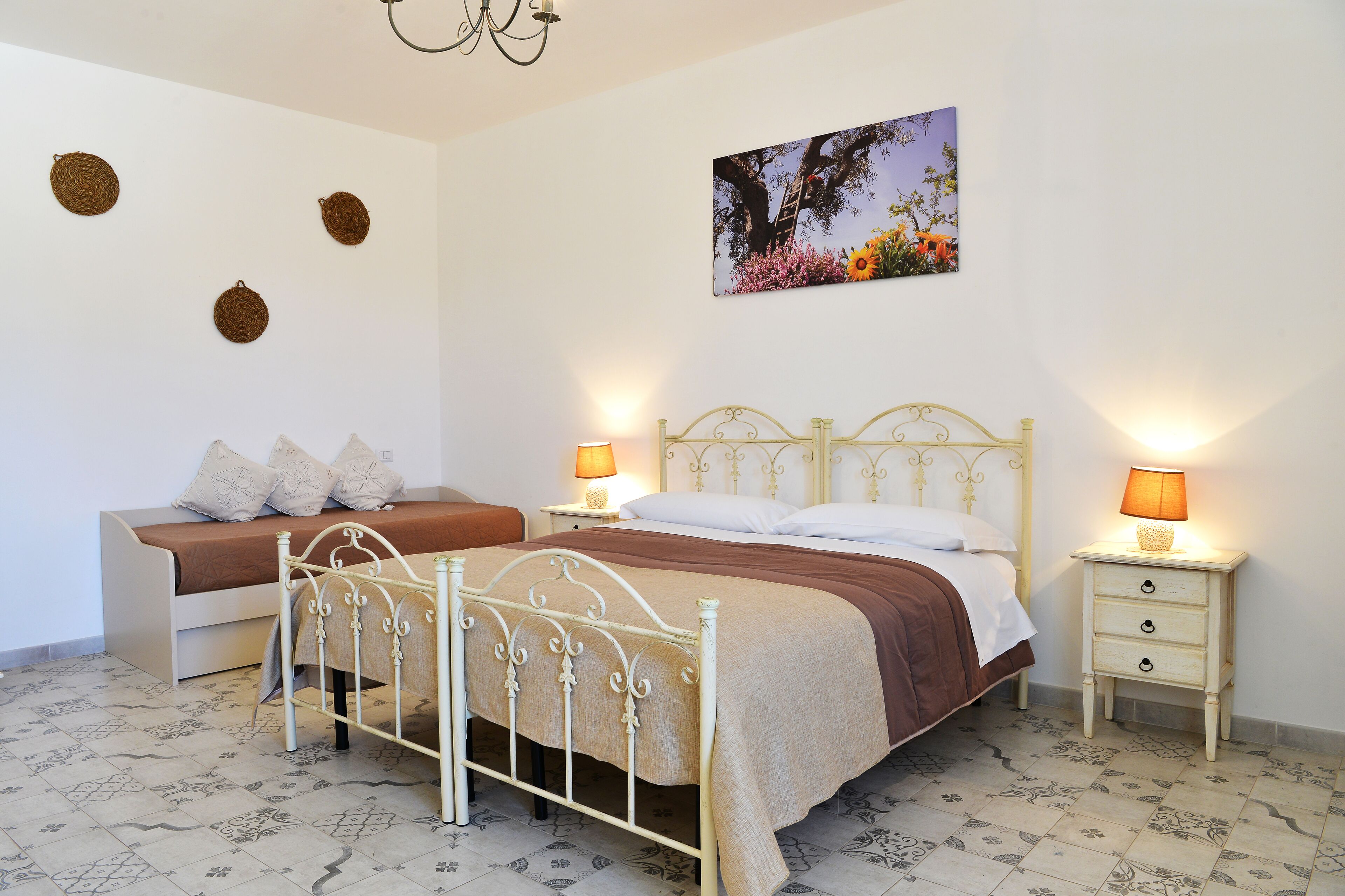 A bedroom with a double bed, a bedside table, a nightstand, and a wall-mounted picture.