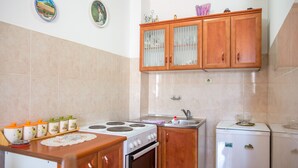 Una cocina con armarios de madera, una estufa, un refrigerador y un lavabo.