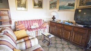A living room with a sofa, a coffee table, a TV, and a cabinet.