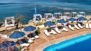 A poolside area with lounge chairs and umbrellas, overlooking a beach and the sea. - Approdo Resort Thalasso Spa (Castellabate)