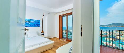 Un dormitorio con cama, un cuadro y vistas al mar y a los barcos.