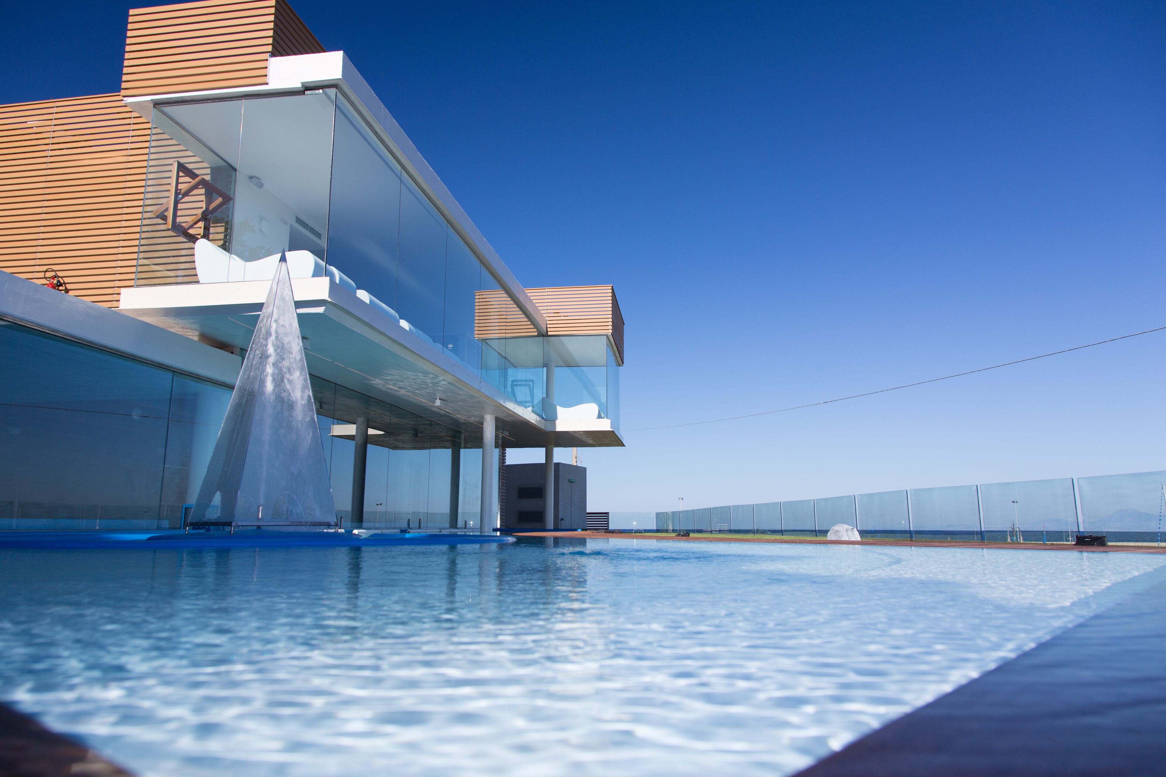 Un bâtiment moderne doté d’une façade en verre et d’un espace piscine.