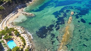 An aerial view of a beach with clear waters, a swimming pool, and umbrellas. - Approdo Resort Thalasso Spa (Castellabate)