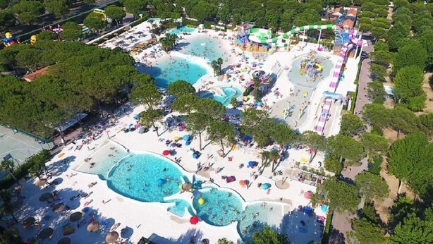 An aerial view of a resort with multiple swimming pools, beach areas, and shaded seating. - Luxury Camp at Union Lido (Cavallino-Treporti)