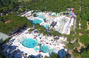An aerial view of a resort with multiple swimming pools, beach areas, and shaded seating. - Luxury Camp at Union Lido (Cavallino-Treporti)