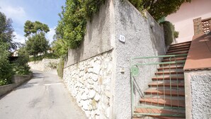 A stone wall with a metal gate leading to a staircase. - Appartamento Trilo La Padulella (Portoferraio)