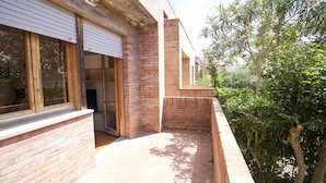 A modern building with a brick facade, large windows, and a small outdoor area with greenery. - Appartamento il Quadrifoglio (Portoferraio)