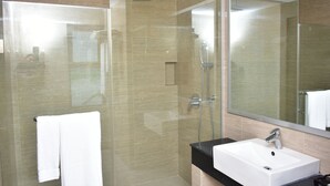 A modern bathroom with a glass-enclosed shower, a white sink, and a large mirror. - Divine Center (Chowgacha)