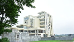 A modern multi-story building with a flat roof and large windows. - Divine Center (Chowgacha)