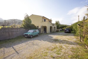 Ein Haus mit Kiesweg, einem geparkten Auto und einer Treppe, die zum Eingang führt.