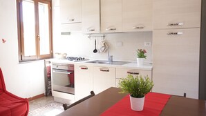 Uma cozinha moderna com área de refeições, incluindo fogão, forno, pia e armários.