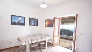 Un coin repas avec une table et des chaises, un sol à motifs et trois tableaux encadrés accrochés au mur.