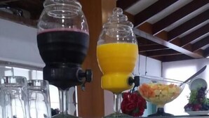 Un bufé con diferentes platillos y un dispensador de jugos.