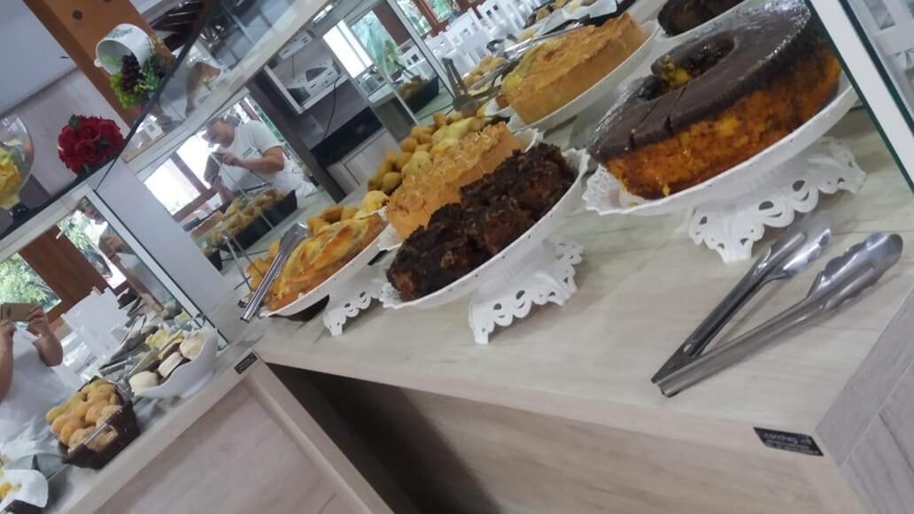 A buffet with various dishes, including cakes and pastries, arranged on a counter with a glass display case.