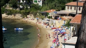 A beach with clear water, people sunbathing, and boats. - Appartamento Il Sottomarino (Portoferraio)