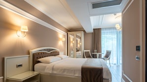 Une chambre d’hôtel avec un grand lit, des tables de chevet, un miroir, une petite table et une chaise.