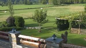 Une terrasse avec des murs en pierre, une table en bois et des chaises.