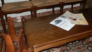 A wooden bench with a newspaper and a magazine on it. - Hostal Restaurante San Poul (Consuegra)