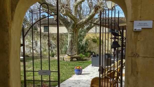 An outdoor area with a stone pathway leading to a seating area, a large tree, and a gate labeled "PRIVÉ". - Clos St Pierre de Fraisse (Avignon)