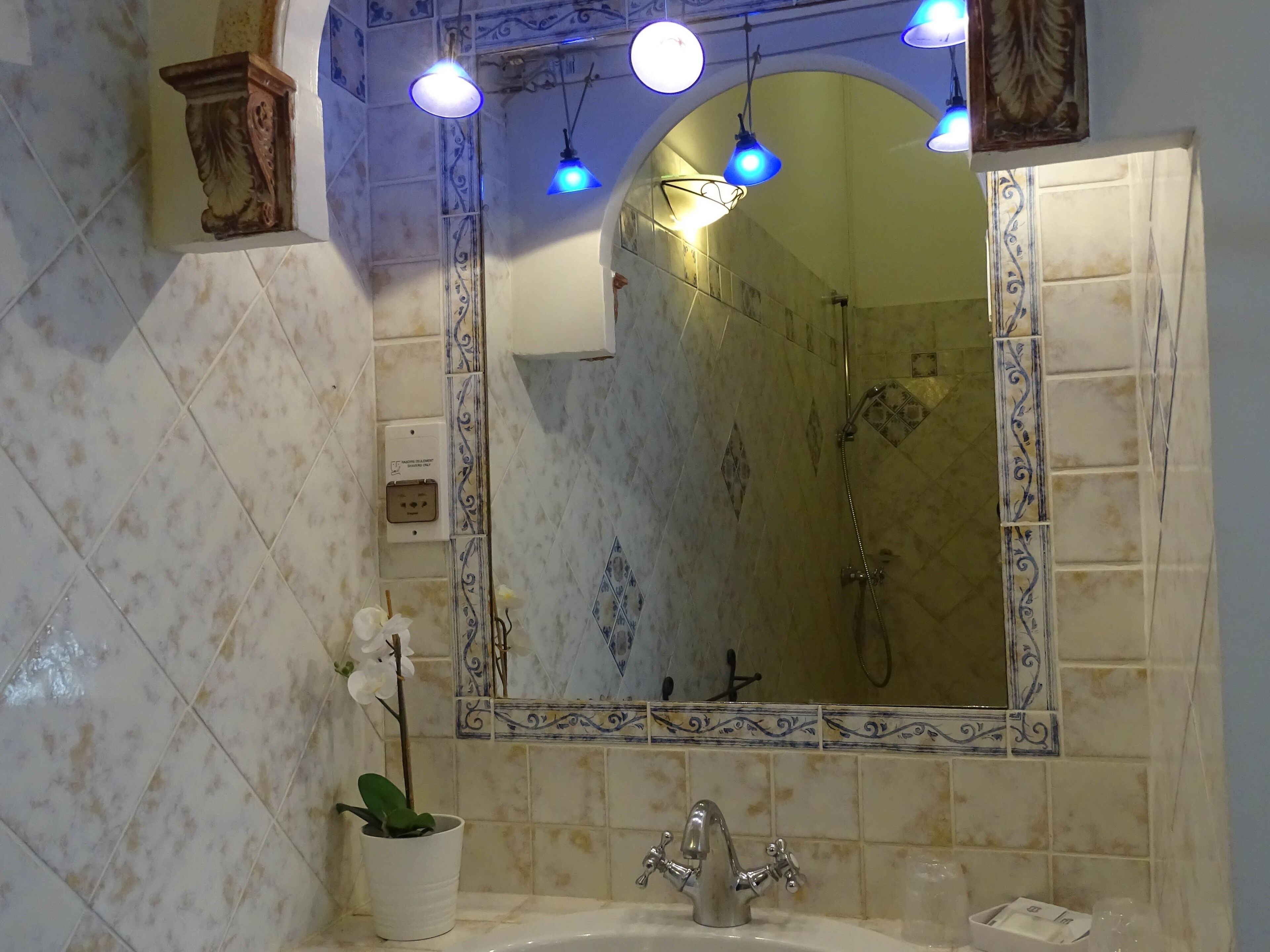 A bathroom with a sink, mirror, and shower.