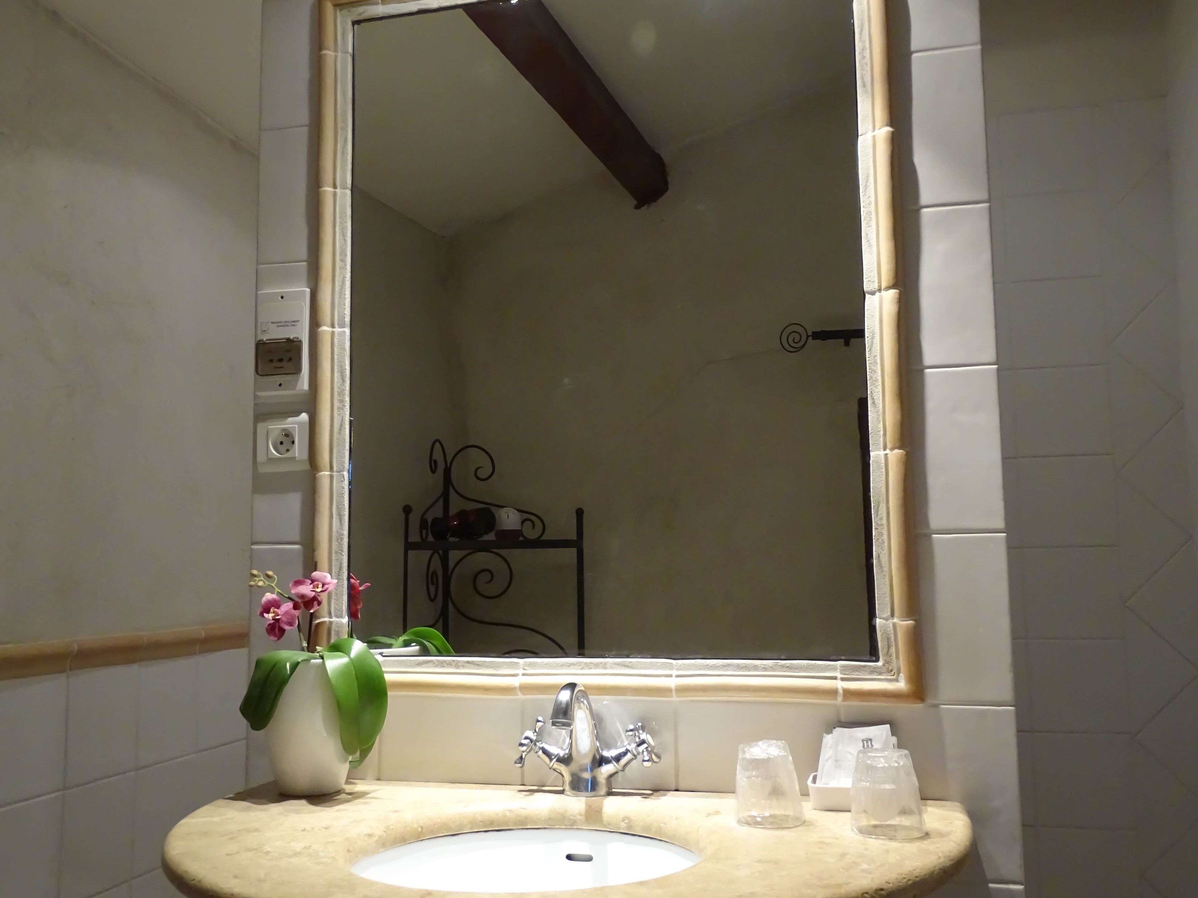 Un baño con un espejo grande, un lavabo y un inodoro.