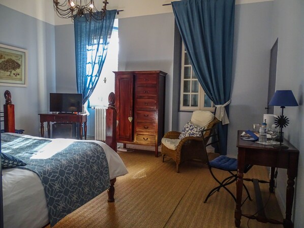 A hotel room with a bed, a desk, a chair, a dresser, a lamp, and a window with curtains. - Clos St Pierre de Fraisse (Avignon)
