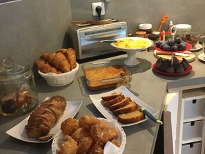 A breakfast buffet with various pastries, bread, and fruits. - Clos St Pierre de Fraisse (Avignon)