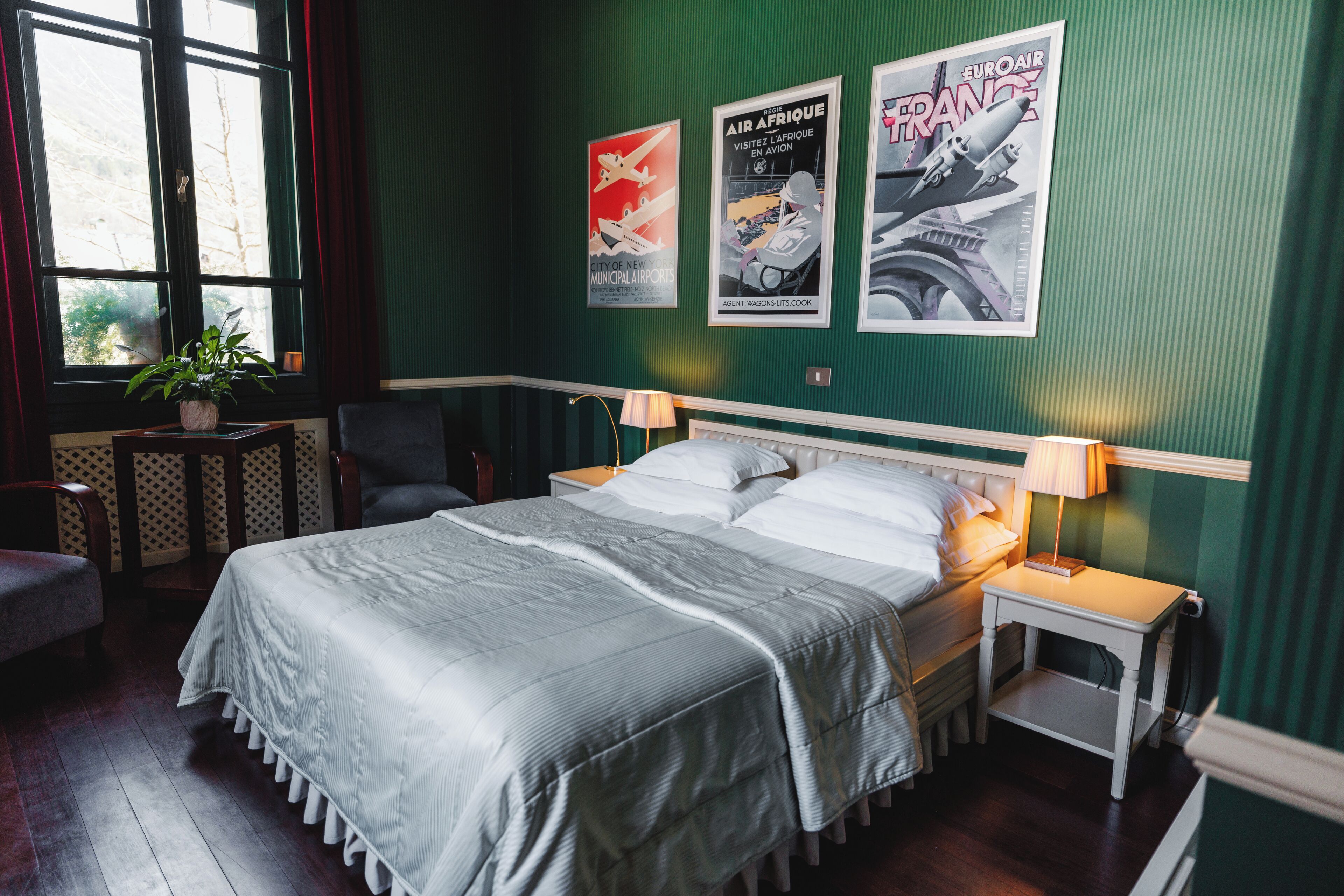 A neatly arranged bedroom with a large bed, bedside tables, a chair, and a window with curtains.