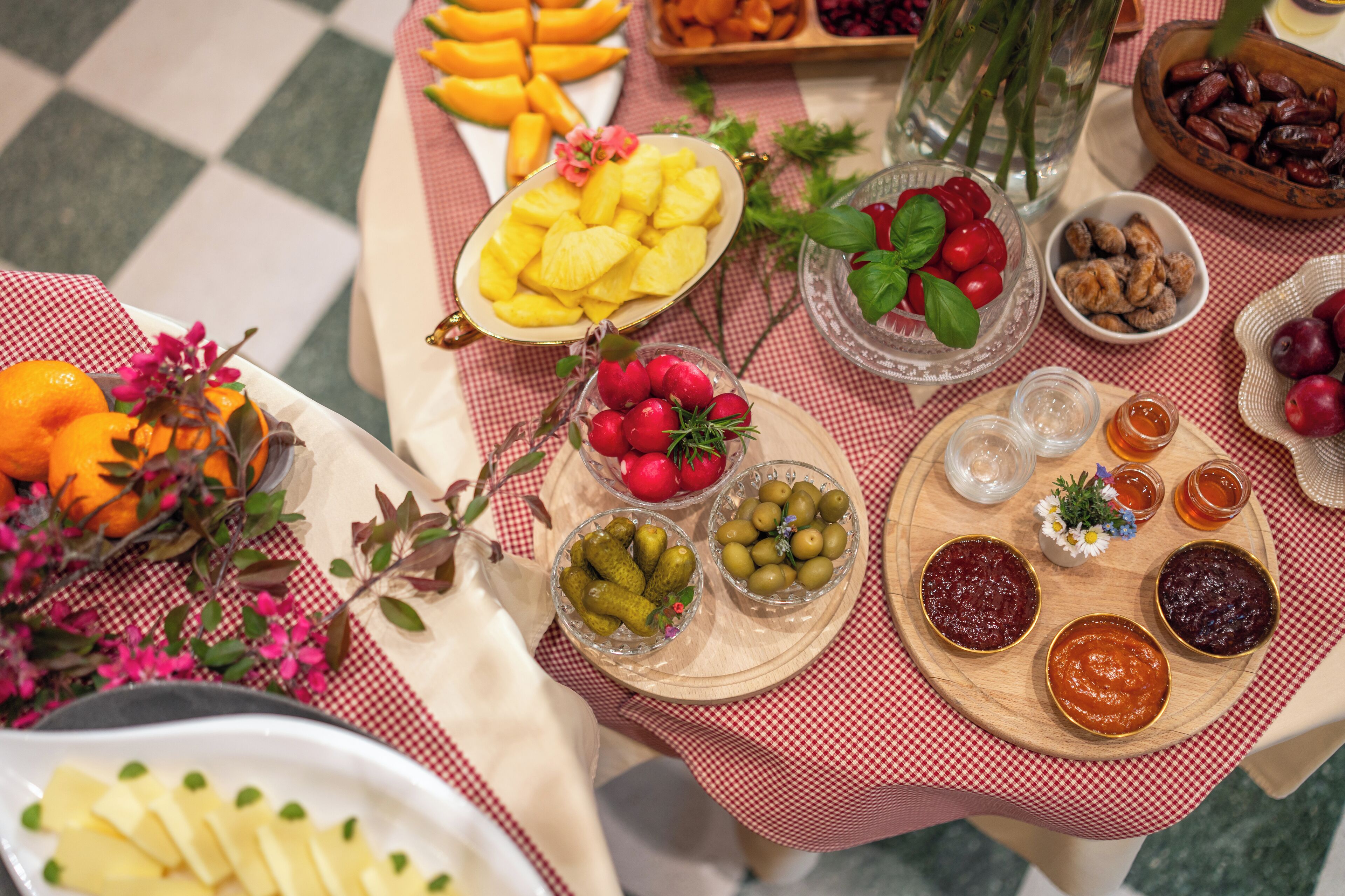 A table with various food items and a checkered tablecloth.