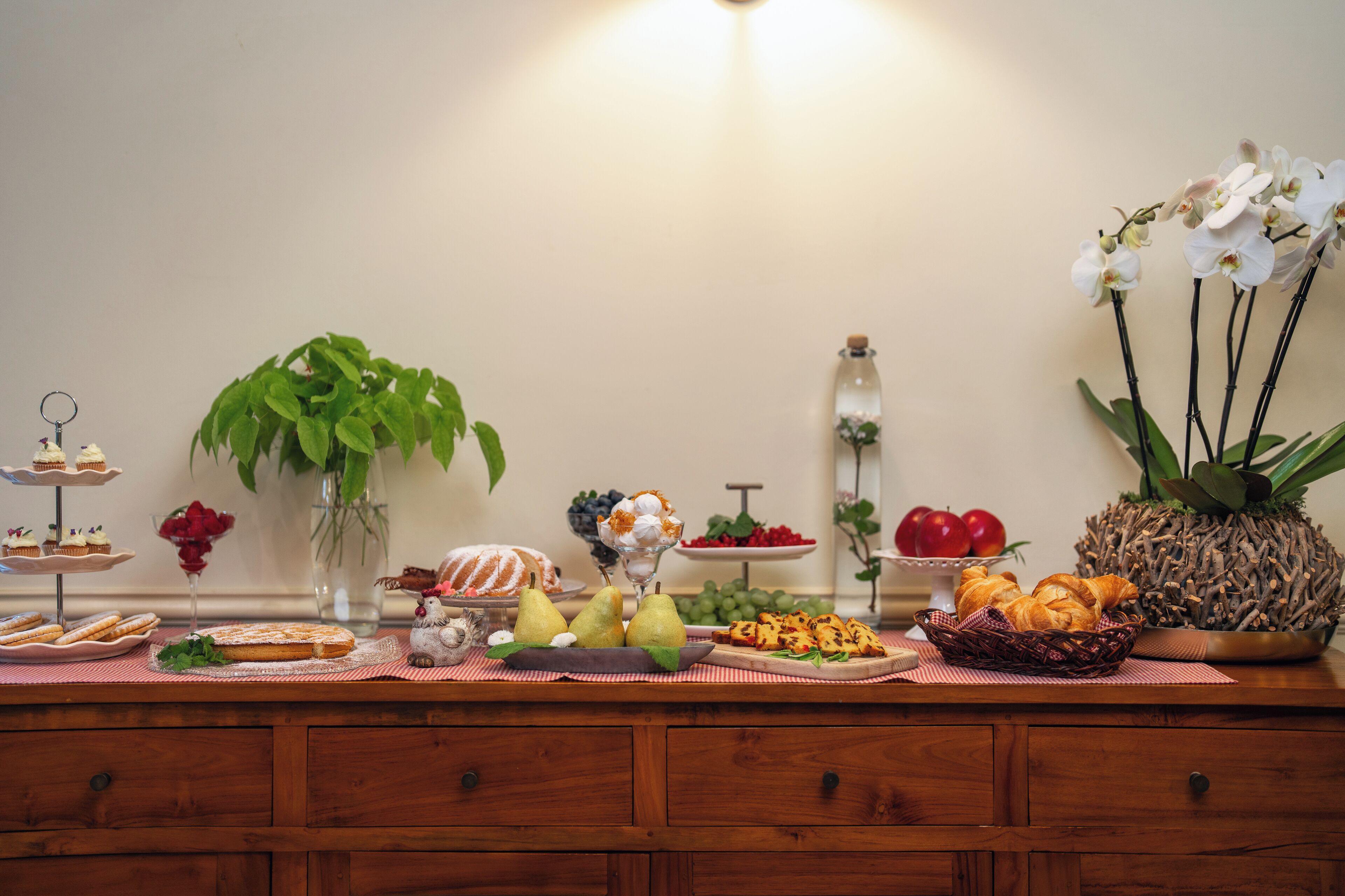 Una mesa de buffet con diferentes alimentos y una planta en maceta.