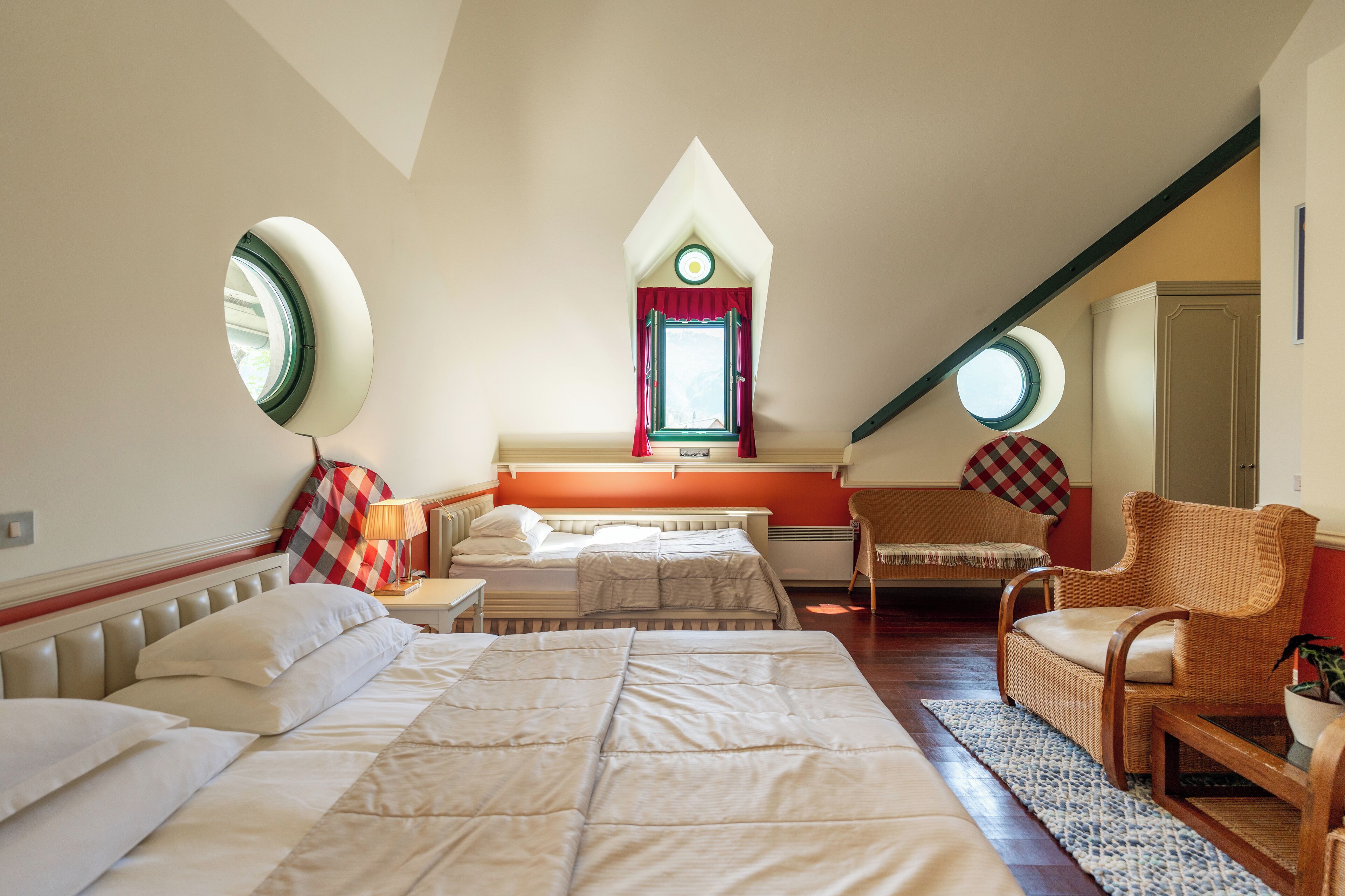 Una camera da letto con due letti, una finestra, una sedia e un tavolino.