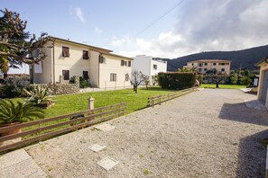 Zona residencial amb un camí pavimentat, una tanca de fusta i un jardí en verd.