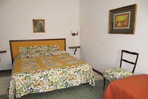 A bedroom with a bed, a chair, and a table. - Appartamento Il Prado (Portoferraio)