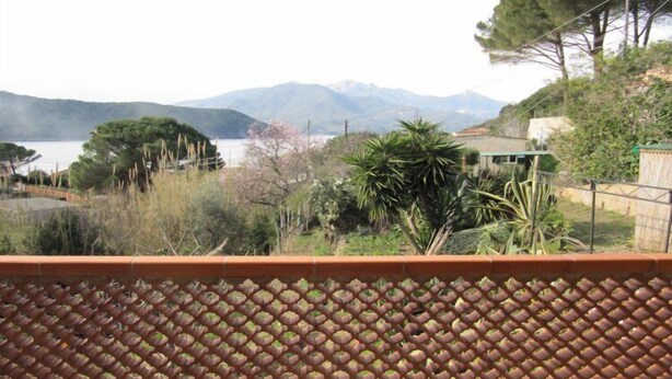 Una terraza con vistas a un lago y montañas.