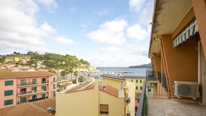 A coastal town with buildings, a marina, and a view of the sea. - Appartamento Quadri Azzurro (Porto Azzurro)