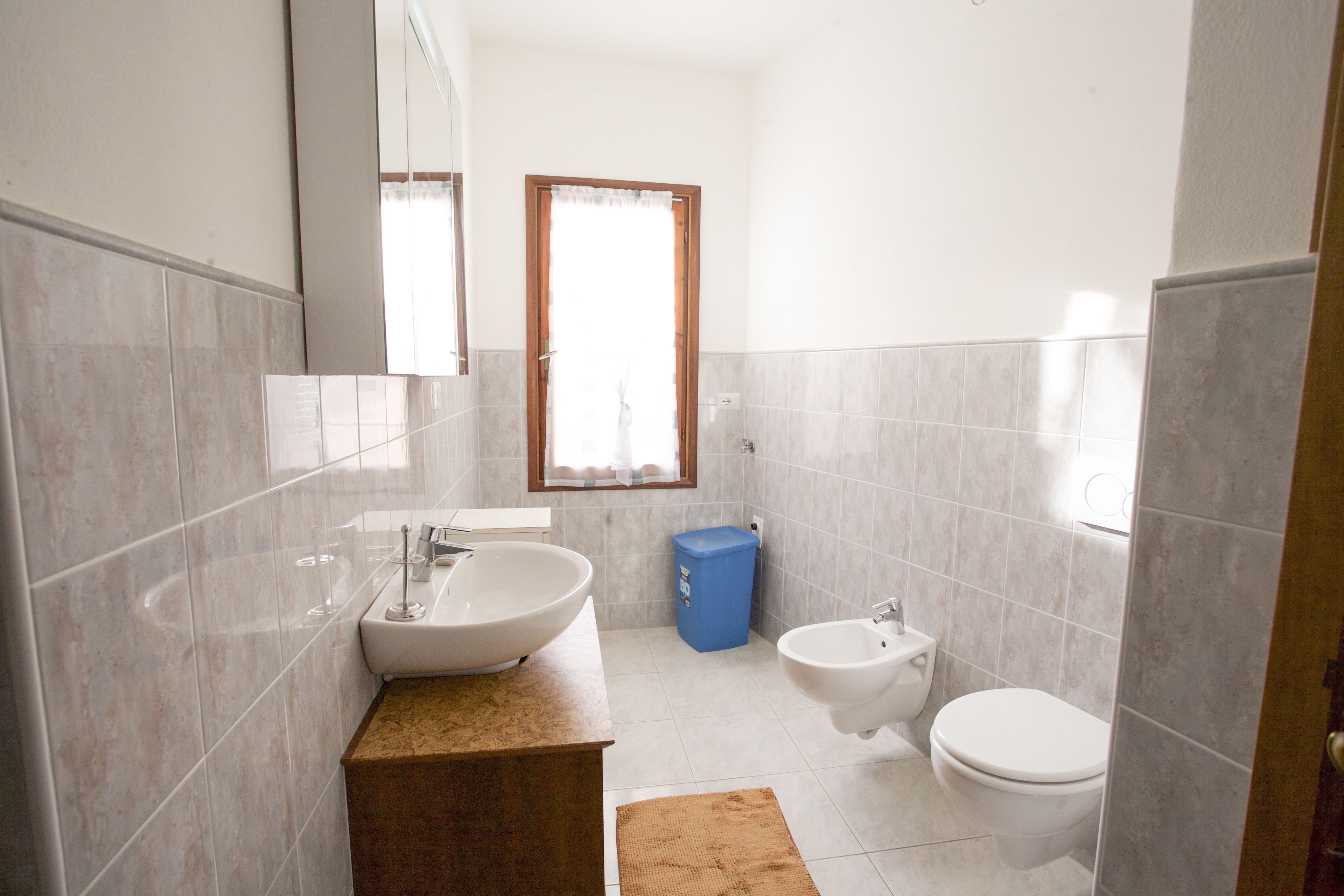 A bathroom with a large sink, a bidet, and a toilet.