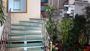 A staircase with glass steps and metal railings, surrounded by potted plants. - Grand Urfa Hotel (Sanliurfa)