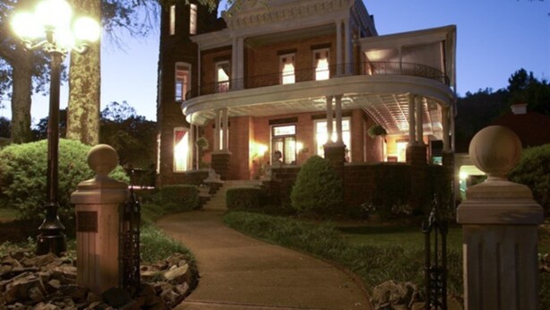 A large, elegant building with a curved entrance, well-maintained gardens, and a pathway leading to the entrance. - 1890 Williams House Inn (Hot Springs)