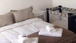 Ein Hotelzimmer mit einem großen Bett, zwei Handtüchern, einem kleinen Tisch und einem Kopfstück mit einem gemusterten Design.